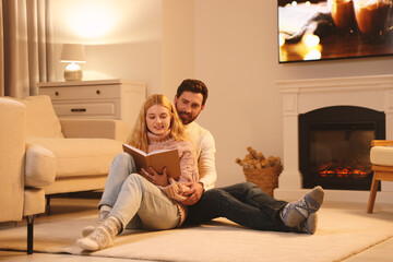 Sticker - Lovely couple reading book near fireplace at home