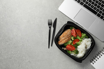 Sticker - Container of tasty food, laptop, cutlery and notebook on light grey table, flat lay with space for text. Business lunch