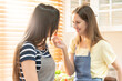 © Wongsakorn - Happy same sex couple feed each other at kitchen. Cheerful LGBTQ lesbian woman feeding salad each other. A beautiful couple of lesbian ladies having a romantic moment in the kitchen.