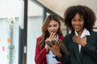 © crizzystudio - Young business people, Asian and African women. Africans holding hands expressing joy and surprise at success in Online business finance together in the office management concept.