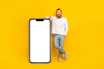 Wall Mural - Full length photo of beard man near big telephone wear shirt jeans shoes isolated on yellow color background