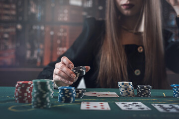 woman playing poker and makes a bet, raises with casino chips