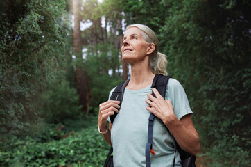 travel, forest and mature woman on hiking journey, jungle adventure and nature backpack with outdoor