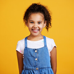 Studio, portrait and happy child with a smile on face isolated on a yellow background. Cute hispanic young girl kid model with happiness, carefree and positive attitude in casual clothes for fashion