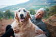 Elderly woman, hiking with dog in forest and adventure, fitness with travel and pet with love and care. Nature, trekking and vitality, mature female in retirement and golden retriever puppy outdoor