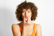 © VISTA by Westend61 - Curly haired woman puckering face against white background