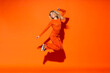 © VISTA by Westend61 - Happy woman jumping against orange background