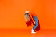 © VISTA by Westend61 - Woman bending over backwards against orange background