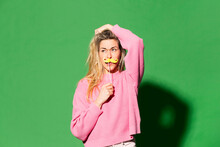 Confused Woman With Hand Raised Standing Against Green Background