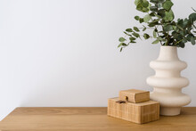 Decorative Storage Box And Green Leaves In Ceramic Vase On Shelf