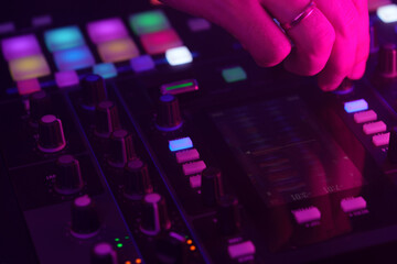 Wall Mural - Hands of a DJ creating and regulating music on dj console mixer at club concert