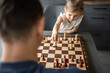© dtatiana - Little girl playing chess with her father at the table in home kitchen. The concept early childhood development and education. Family leisure, communication and recreation.