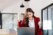 © Jirapong - Beautiful young teen asian businesswomen using computer laptop with hands up in winner is gesture, Happy to be successful celebrating achievement success