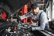 © Serhii - Professional Mechanic is Working on a Car in a Car Service.