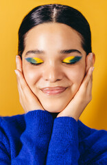 Wall Mural - Loving her makeup look, woman embraces her face in a studio