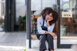 © amnaj - Female shopkeeper sitting stressed out at the store entrance frustrated by the economic impact.
