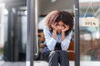 © amnaj - Female shopkeeper sitting stressed out at the store entrance frustrated by the economic impact.