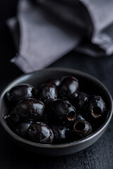 Poster - Pitted black olives in bowl on kitchen table.