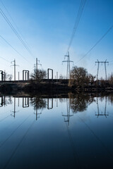 Mirror image of high-voltage power lines in a dark lake