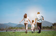 © Kiattisak - Happy family in the nature travel. family on weekend playing together in the meadow with river Parents hold the child and daughter hands.health life insurance plan concept.