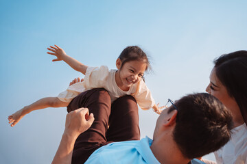 happy family in the park on weekend. family enjoying together in the meadow with river parents hold 