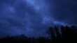 time lapse video of dark clouds in the evening with trees, dramatic movement of clouds before a storm,dramatic sky,