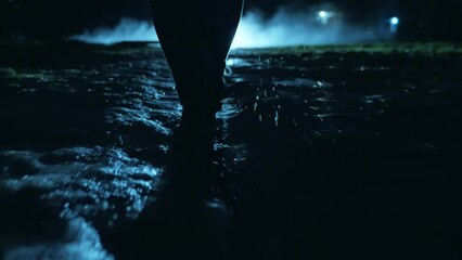 Wall Mural - rear view of a man walking down a dark street through fog and gloom