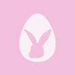 Jajko wielkanocne i głowa królika na różowym tle. Zając wycięty w jajku. Symbole świąt. Prosta ilustracja w minimalistycznym stylu na kartki świąteczne, zaproszenia, banery, plakat.