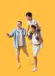 © Pixel-Shot - Happy little boy with his dad and grandfather on yellow background