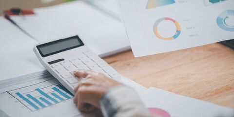Aufkleber - Businessman calculating figures in company financial documents with a calculator,analysis of company financial data,Planning to assess and review budgets,concept of finance and investment.