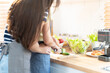 © Wongsakorn - lesbian couple standing in kitchen. Lesbian Couple Standing in a Modern Kitchen Behind a Counter Cooking Food Together. in love LGBT freedom concept. loving and caring couple cooking. selective focus.