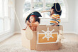 Playing, box boat and pirate children role play, fantasy imagine or pretend in cardboard container. Telescope, fun home game or sailing black kids on Halloween cruise adventure with yacht captain