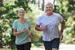© Nina/peopleimages.com - Senior couple, exercise and running outdoor for happy workout and training for fitness. Elderly man and woman laugh for cardio, health and wellness on run in nature forest for healthy retirement