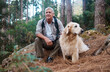 © Nina/peopleimages.com - Adventure, explore and man hiking with her dog, pet or animal in the winter forest for exercise, workout or fitness. Trekking, travel and elderly or senior male trekking with a puppy on holiday
