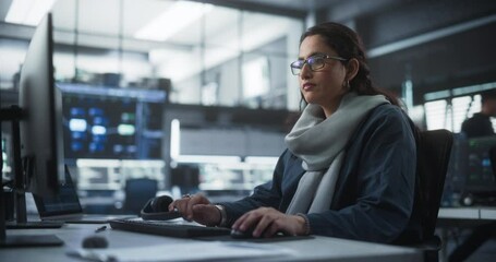 Fototapete - Portrait of a Thoughtful South Asian Engineer Working on Computer in a Technological Corporate Office. Young Woman Writing Software Code for an Innovative Internet and Software as a Service Project