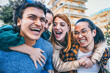 © Nicolas Micolani - Group of young trendy friends having fun outdoors at city street-Happy college student making  piggyback pose enjoying holiday  -Youth culture with multiracial people- Friendship Life style concept