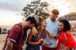 © bernardbodo - Friends looking up concerts on cellphone at music festival.