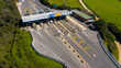 Aerial view of an Italian highway toll booth. There are lanes for paying the toll by debit card, cash or telepass.