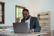 © Jirapong - middle aged man American African business man holding computer laptop with hands up in winner is gesture, Happy to be successful celebrating achievement success