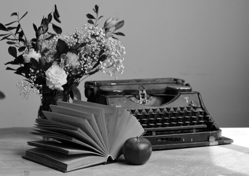 Still life with an old open book on a desk. Retro style photo. Vintage objects on a table. 