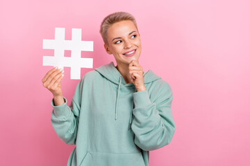 Photo portrait of lovely young lady hold hashtag touch chin look empty space dressed stylish khaki outfit isolated on pink color background