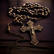 Christian rosary with metal crucifix on wooden background.