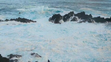 Wall Mural - Slow motion of crashing waves on rocks. White foam from the splashing waves