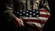 Ein Soldat hält andächtig die Flagge der Vereinigten Staaten von Amerika auf seinem Arm (Generative AI)