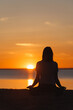 © MyJuly - soft selective focus, yoga meditation, silhouette of woman at sunset in lotus position. health recreation and sports, outdoor training. poster.person is engaged in breathing practices. mental health
