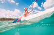 © Soloviova Liudmyla - Underwater view angle to a smiling blonde teenage boy in fashion sunglasses rowing single sit kayak with palm grove background. Active people summer vacation sea concept image, Le Morne, Mauritius.