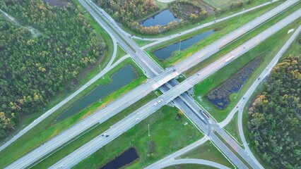 Wall Mural - Aerial view of freeway overpass junction with fast moving traffic cars and trucks. Interstate transportation infrastructure in USA