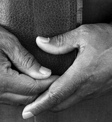 praying to God with hand on the bible on lack background stock photo