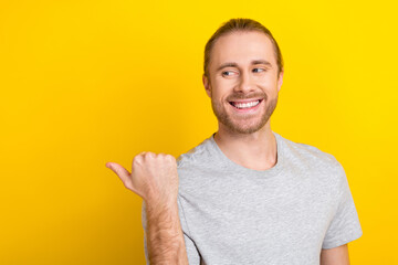 Sticker - Photo of cheerful satisfied glad man wear trendy grey clothes arm direct empty space nice proposition isolated on yellow color background