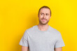 Photo of uncertain unsure man watching empty space banner poster weird proposition isolated on yellow color background